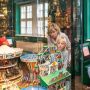 Kind und Mutter betrachten Kinderspielzeug in Vitrine