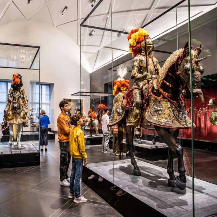 Kinder bestaunen ein großes eisernes Pferd, auf dem ein Ritter in seiner verzierten Rüstung sitzt, im Riesensaal der Rüstkammer
© SKD, Foto: Carina Sonntag