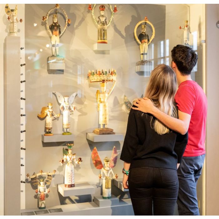 Besucher betrachten eine Vitrine mit Ausstellungsobjekten