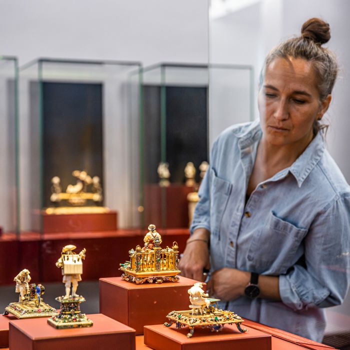 Besucherin vor Vitrine mit goldenen Kunstobjekten von Johann Heinrich Köhler 
© SKD, Foto: Carina Sonntag